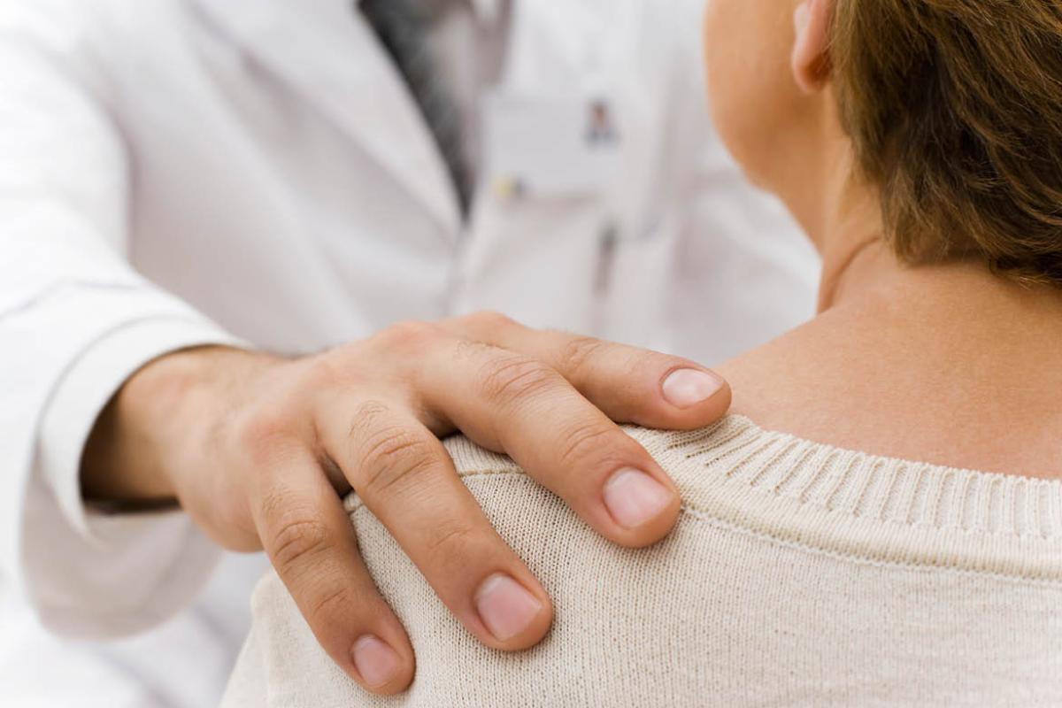 Doctors hand on patient shoulder